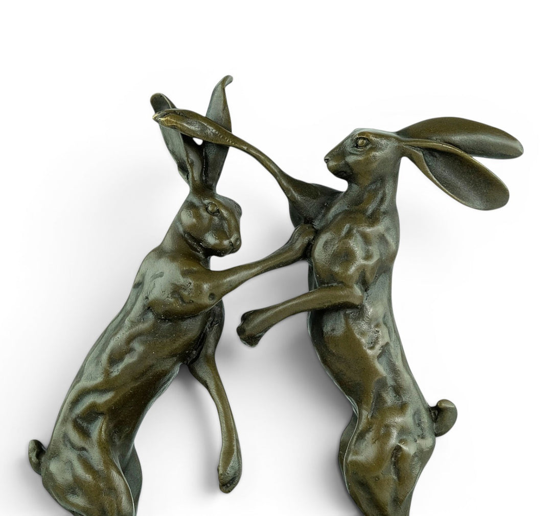 Escultura de bronce de dos liebres boxeadoras