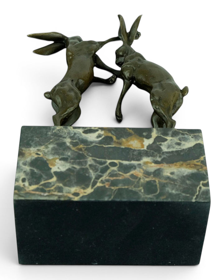 Escultura de bronce de dos liebres boxeadoras