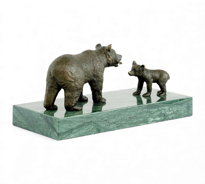 Escultura de bronce de una osa grizzly alimentando a su osezno