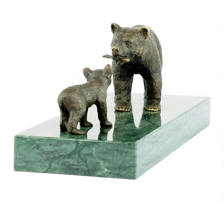 Escultura de bronce de una osa grizzly alimentando a su osezno