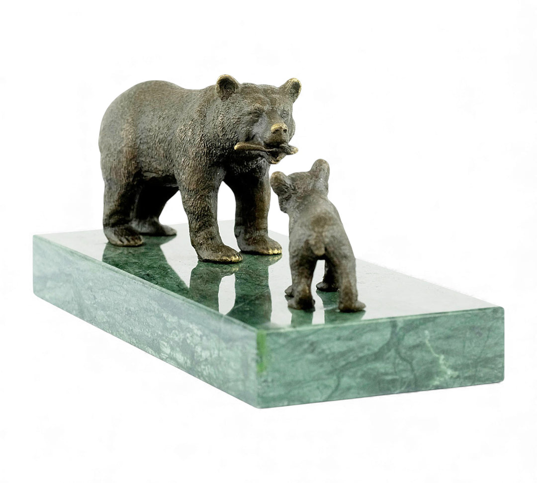 Escultura de bronce de una osa grizzly alimentando a su osezno