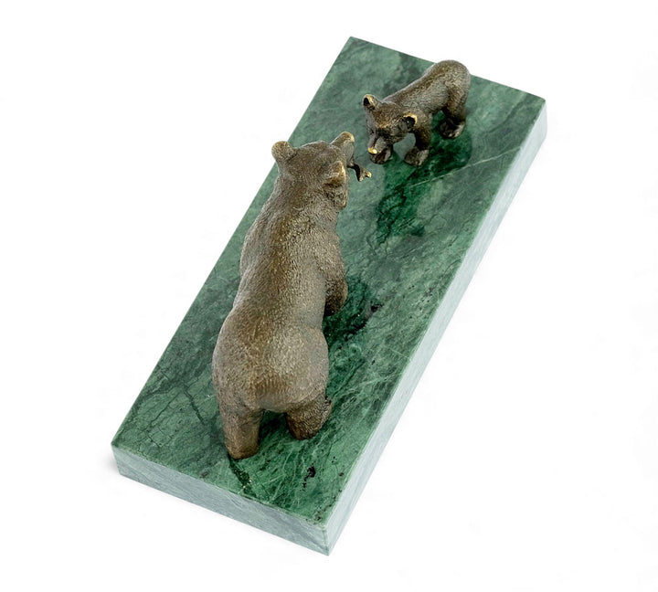 Escultura de bronce de una osa grizzly alimentando a su osezno