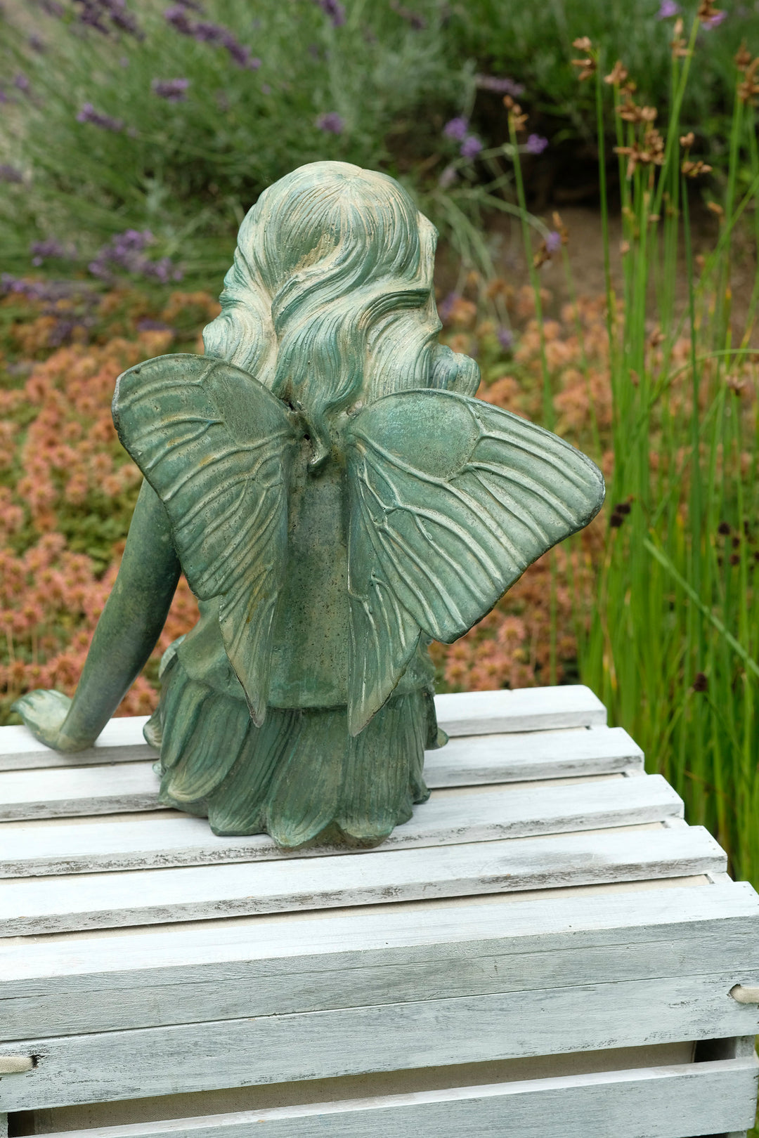 Bronze sculpture of a winged fairy with a butterfly - green patina