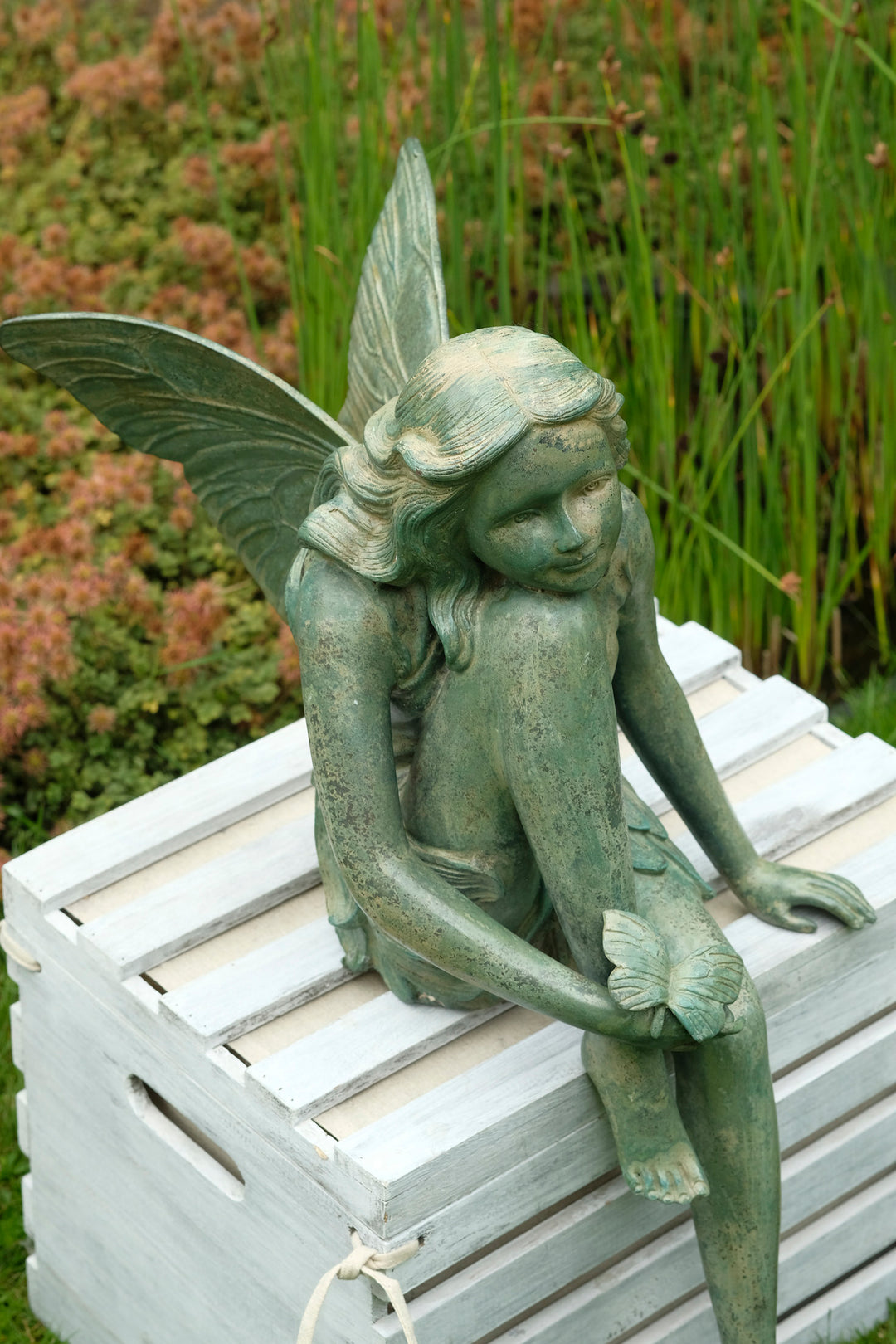 Bronze sculpture of a winged fairy with a butterfly - green patina