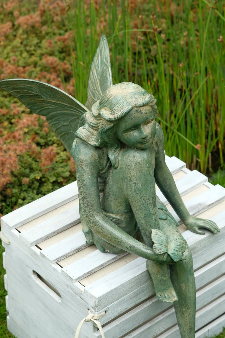 Bronze sculpture of a winged fairy with a butterfly - green patina