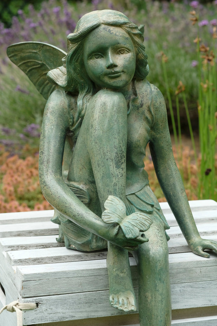 Bronze sculpture of a winged fairy with a butterfly - green patina