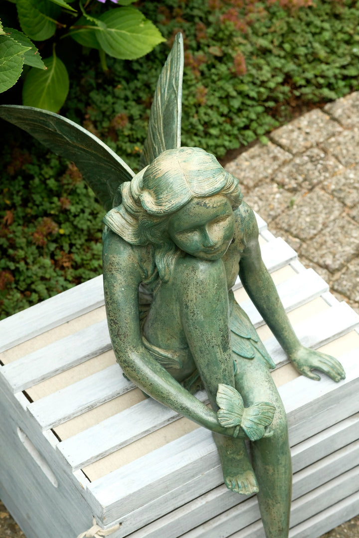 Bronze sculpture of a winged fairy with a butterfly - green patina