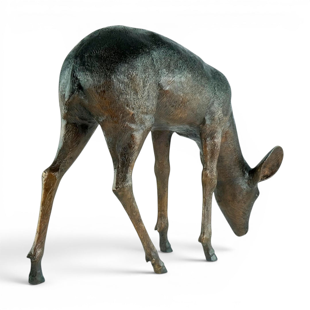 Escultura de bronce de un ciervo pastando