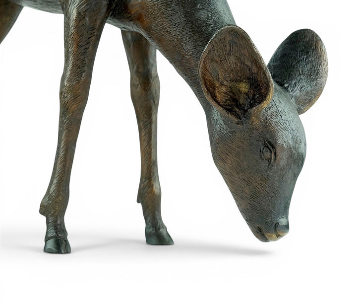Escultura de bronce de un ciervo pastando