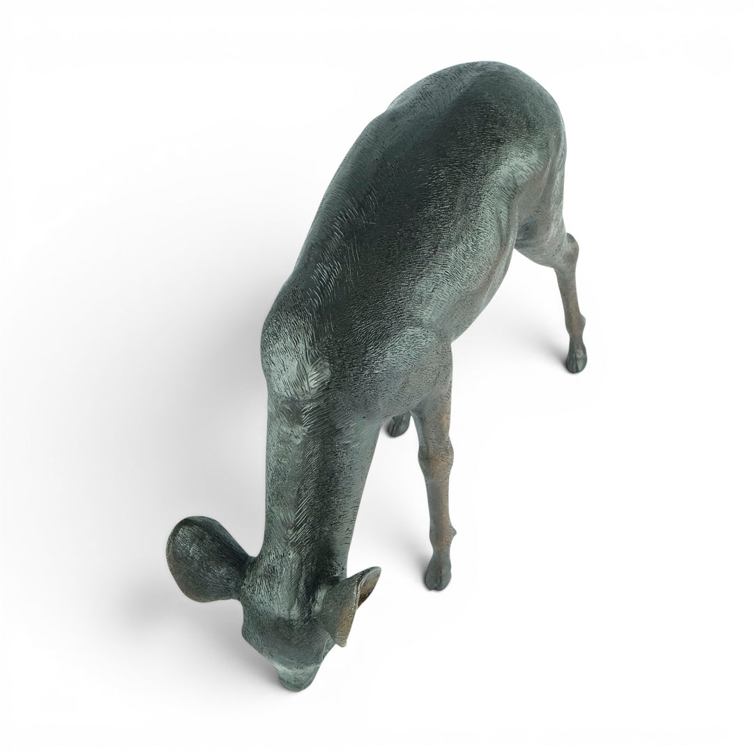 Escultura de bronce de un ciervo pastando