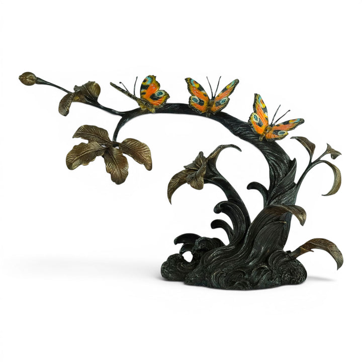 Escultura de bronce de tres mariposas en una rama