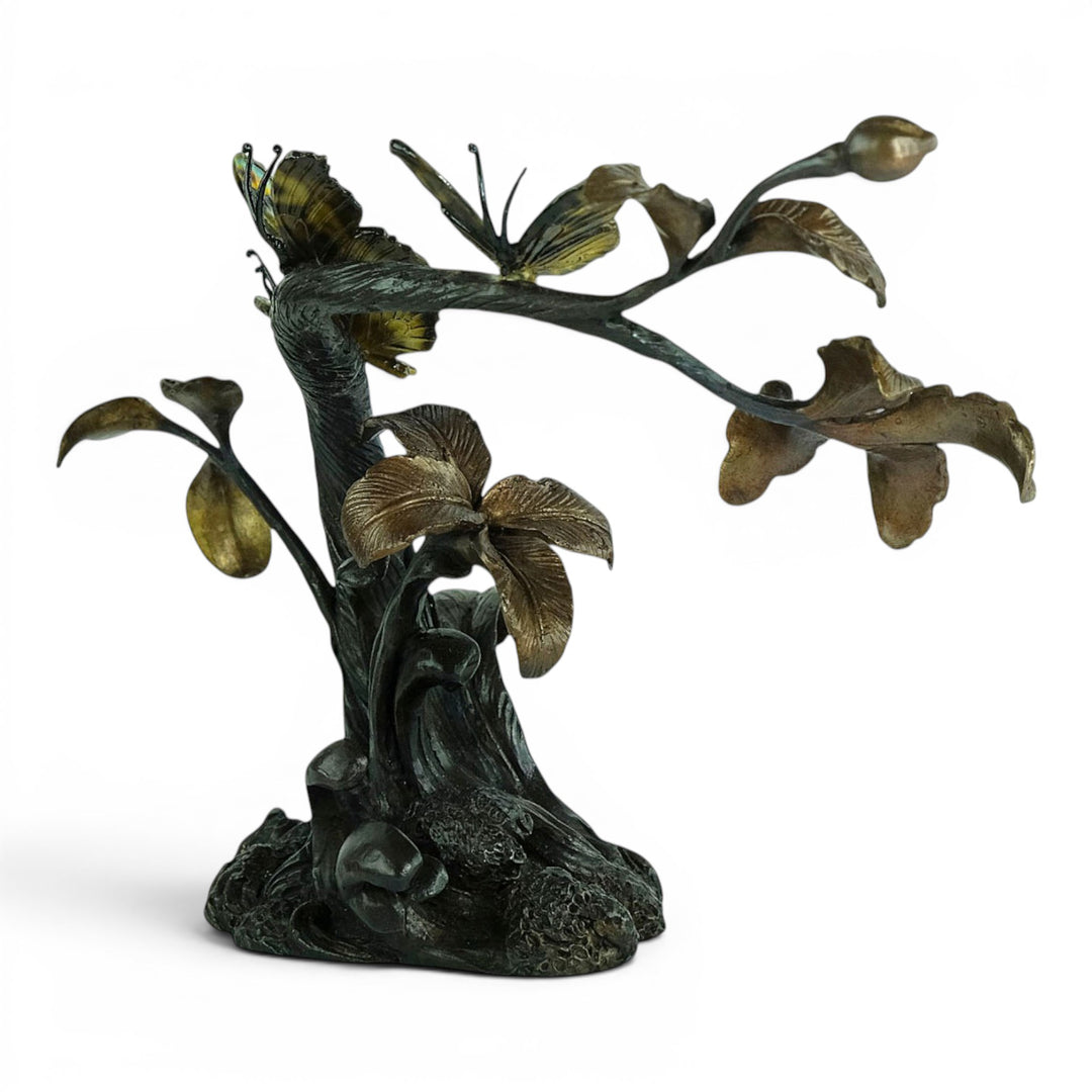 Escultura de bronce de tres mariposas en una rama