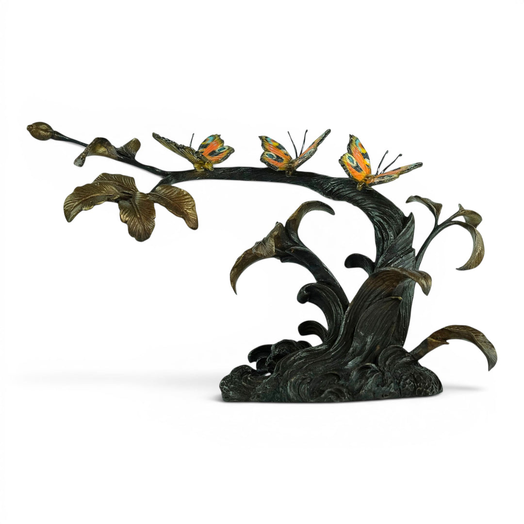 Escultura de bronce de tres mariposas en una rama