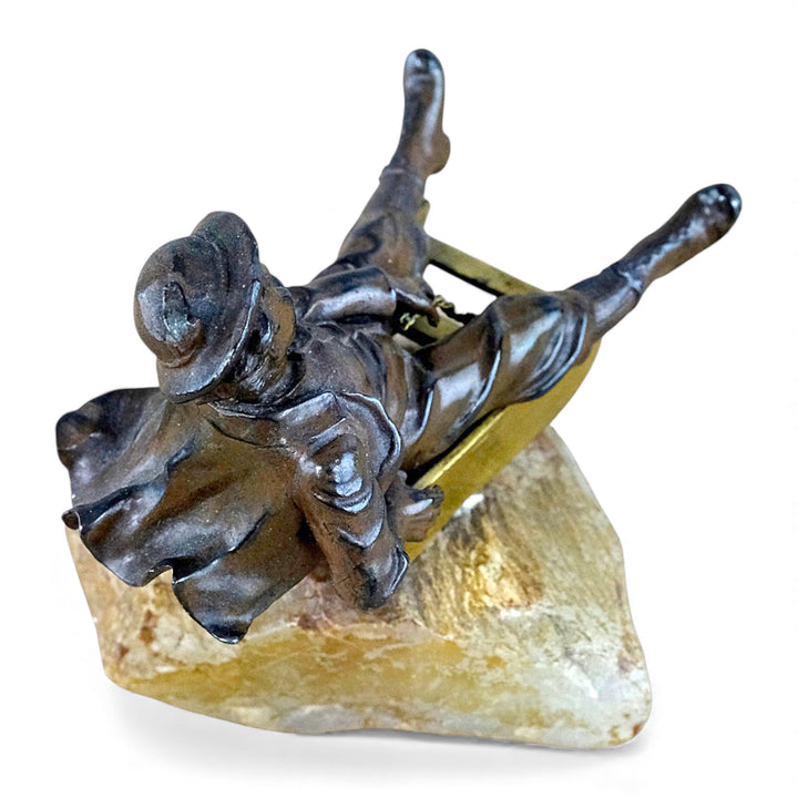 Escultura antigua de bronce de un niño en un trineo.