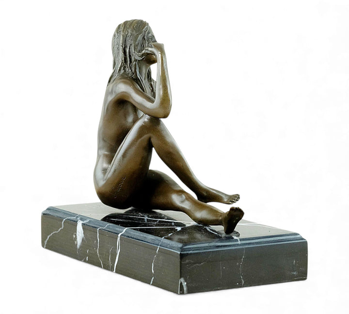 Escultura de bronce de una mujer desnuda coqueta