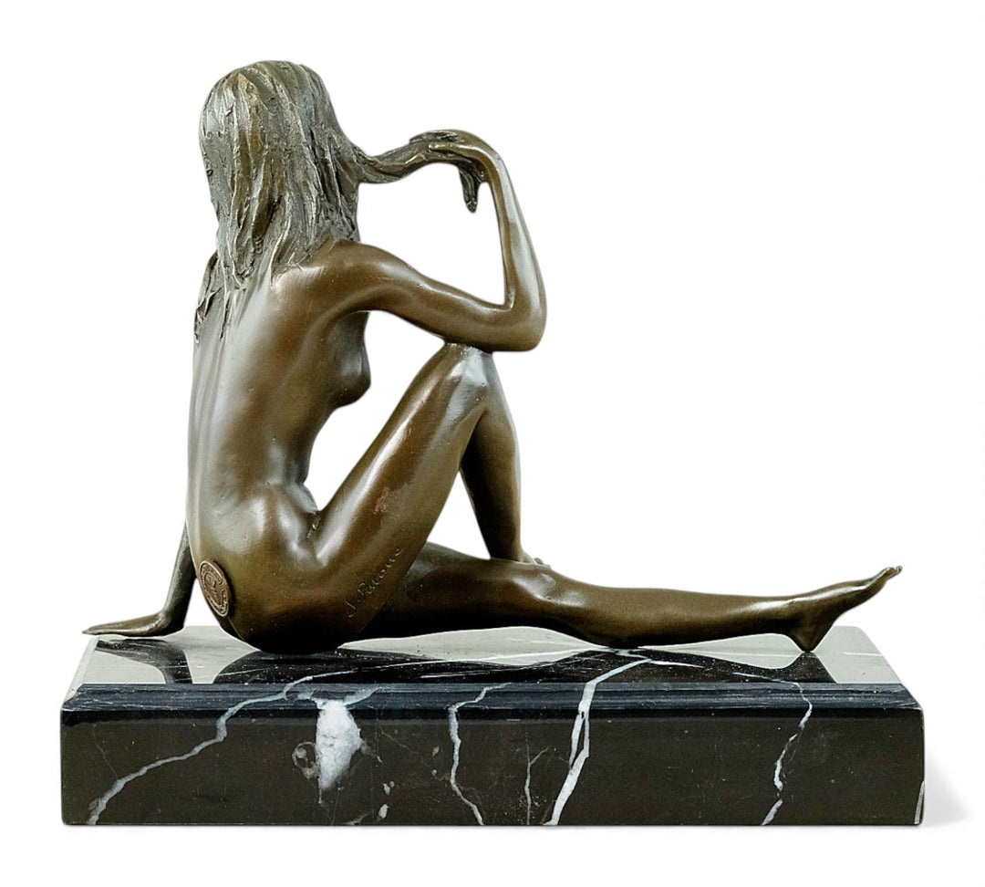 Escultura de bronce de una mujer desnuda coqueta