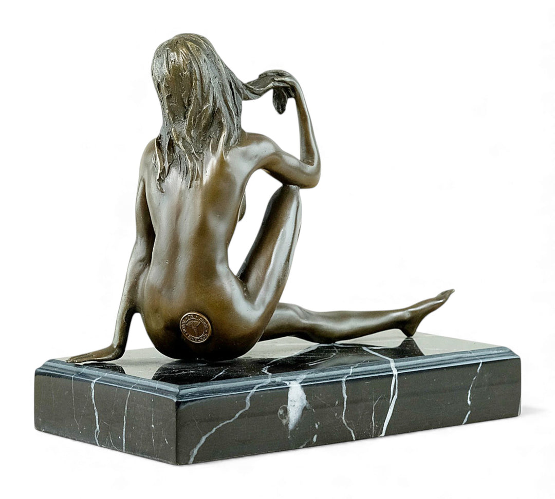 Escultura de bronce de una mujer desnuda coqueta