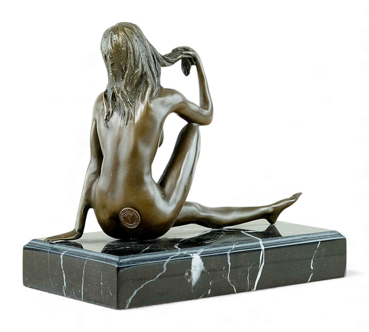 Escultura de bronce de una mujer desnuda coqueta