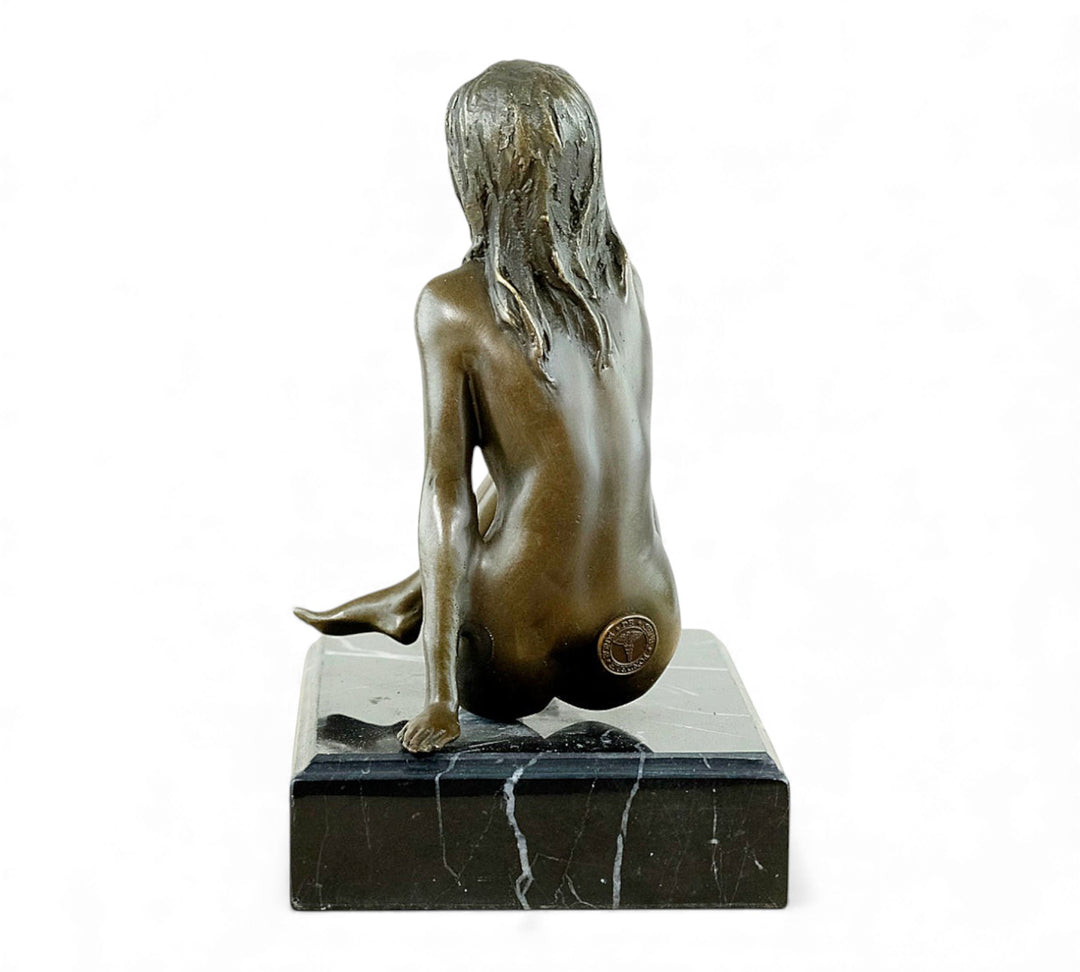 Escultura de bronce de una mujer desnuda coqueta