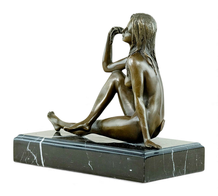 Escultura de bronce de una mujer desnuda coqueta