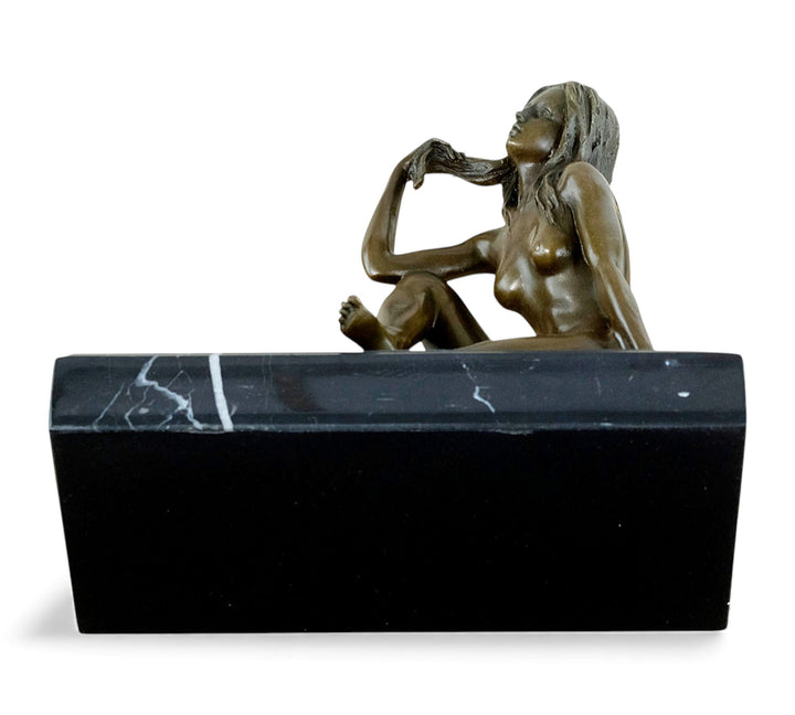 Escultura de bronce de una mujer desnuda coqueta