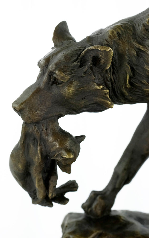 Bronze sculpture of a wolf carrying her young