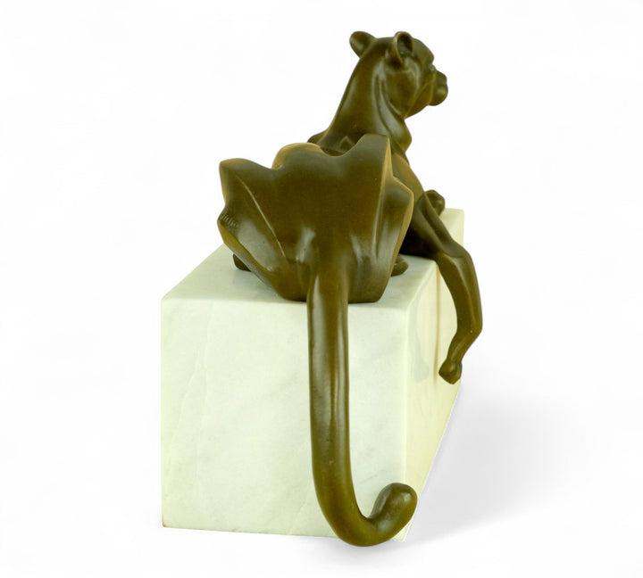 Bronzen sculptuur van een panter in kubistische stijl, liggend op een wit marmeren voetstuk
