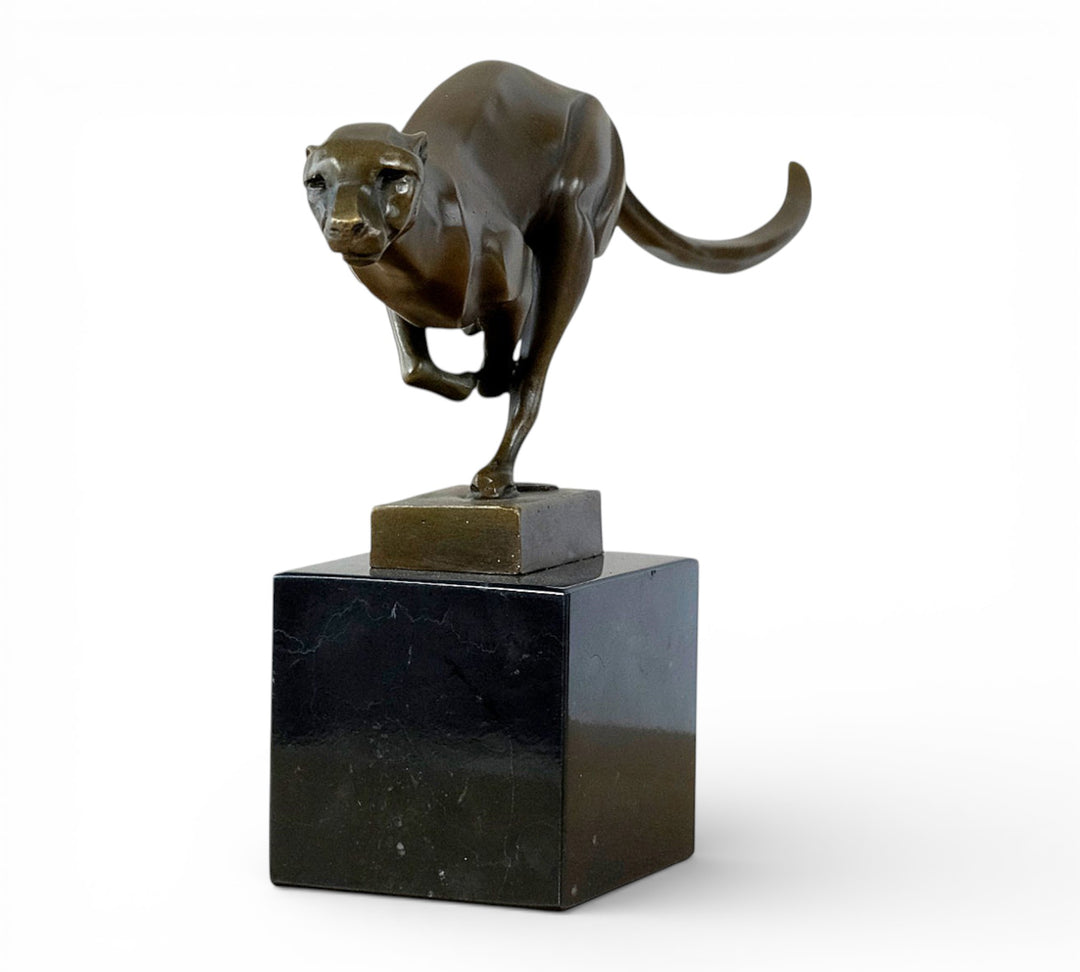 Escultura de bronce de un guepardo corriendo a toda velocidad