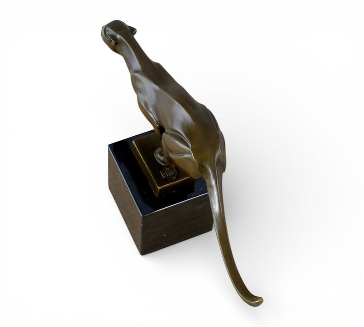 Escultura de bronce de un guepardo corriendo a toda velocidad