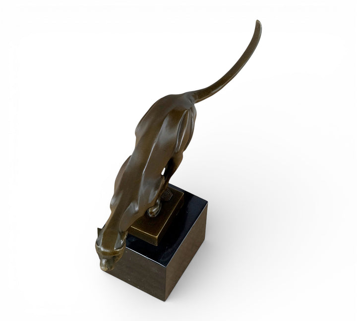 Escultura de bronce de un guepardo corriendo a toda velocidad