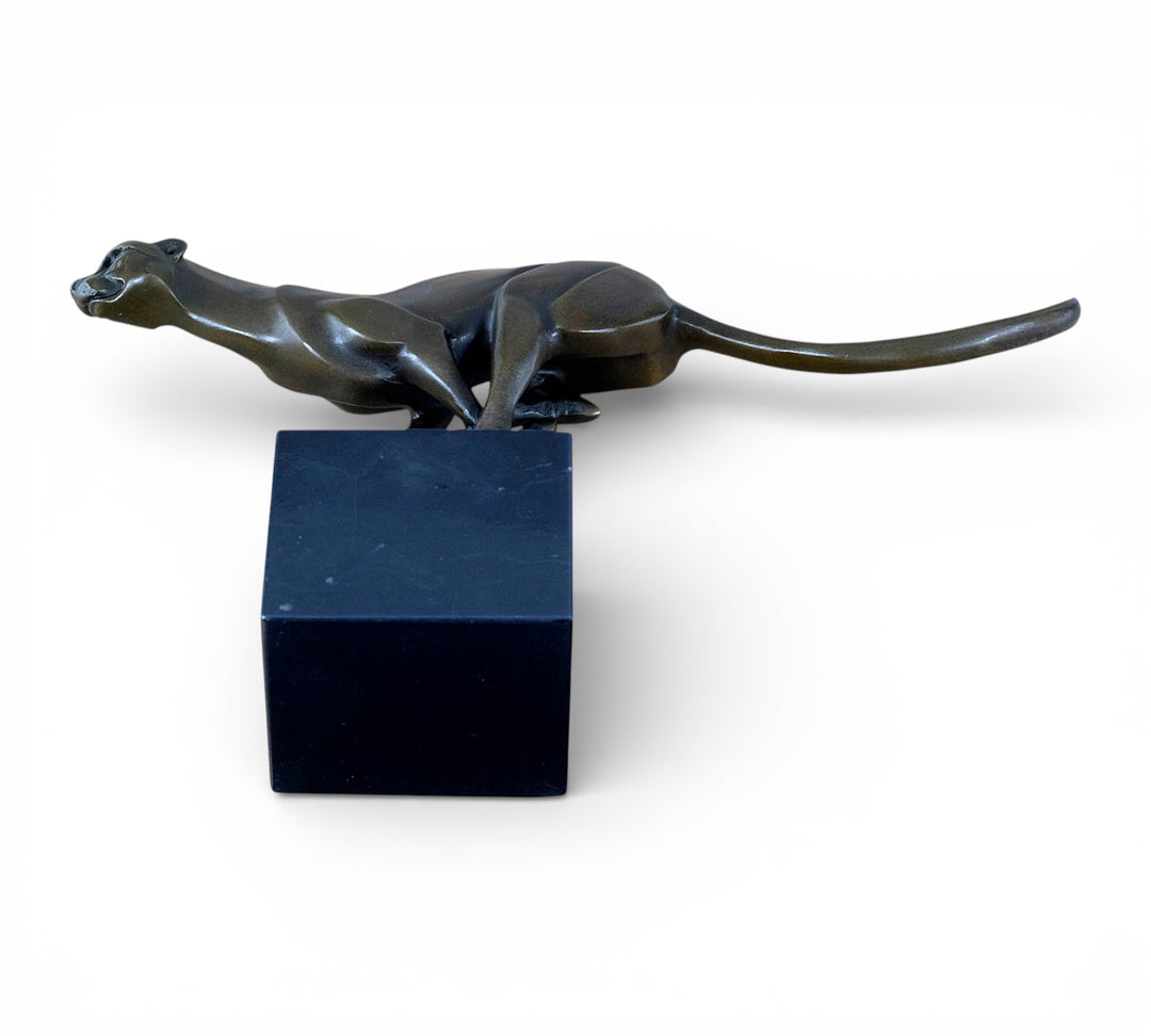 Escultura de bronce de un guepardo corriendo a toda velocidad