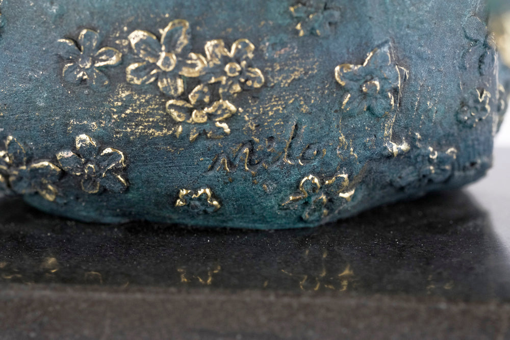 Modern bronze sculpture of a female sitting in a graceful pose