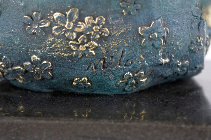 Modern bronze sculpture of a female sitting in a graceful pose