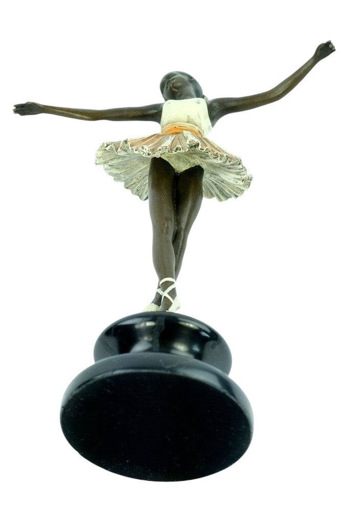 Bronze sculpture of a ballerina standing tip-toe wearing a white tutu