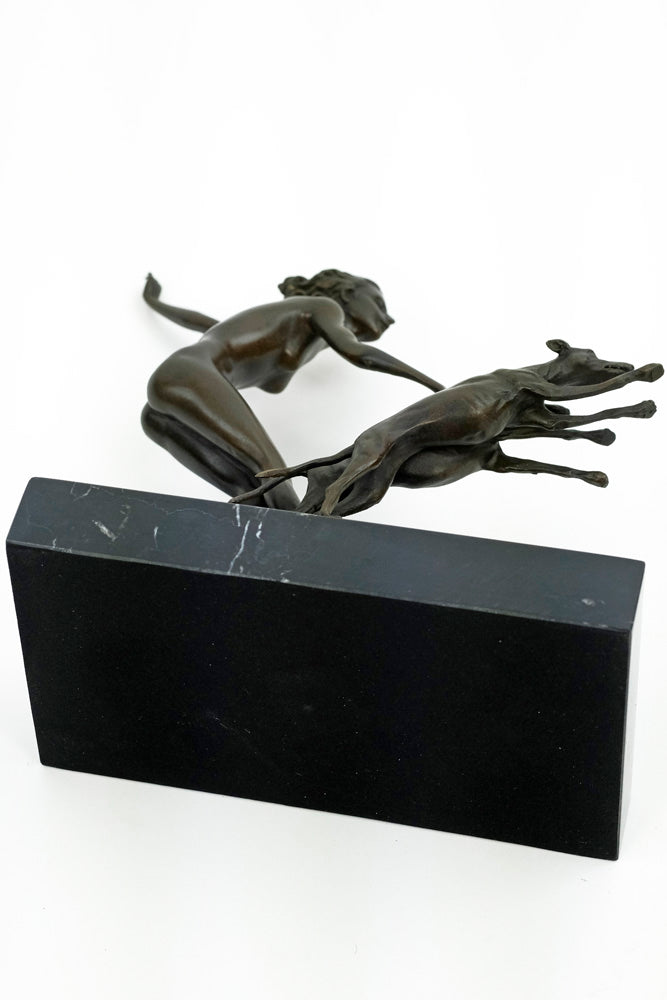 Bronze sculpture of a female running with three dogs