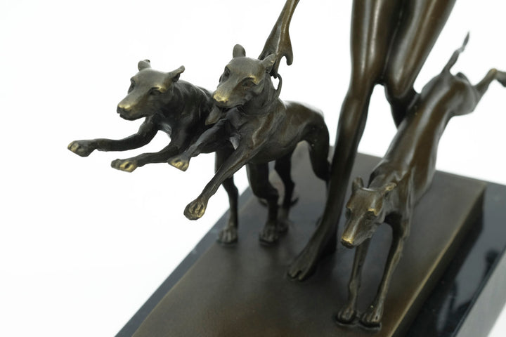 Bronze sculpture of a female running with three dogs