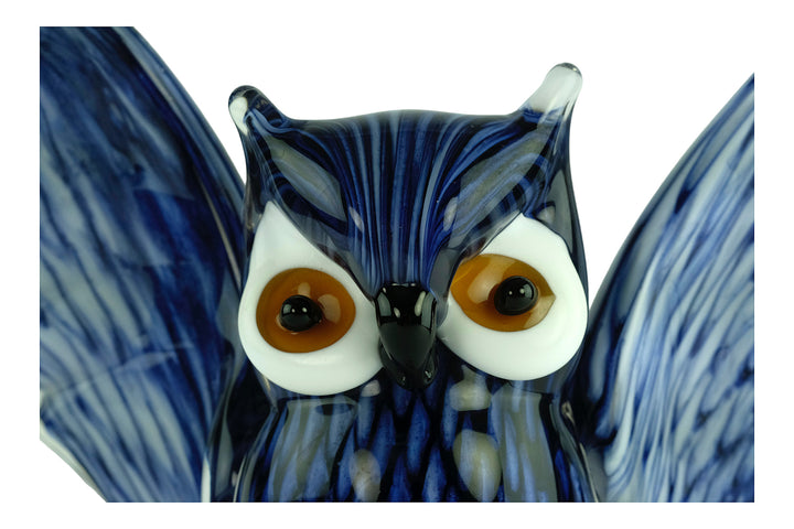 Colourful glass sculpture of an owl with wings spread