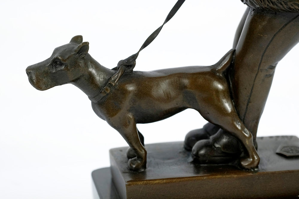 Bronze sculpture of a young girl walking her dog