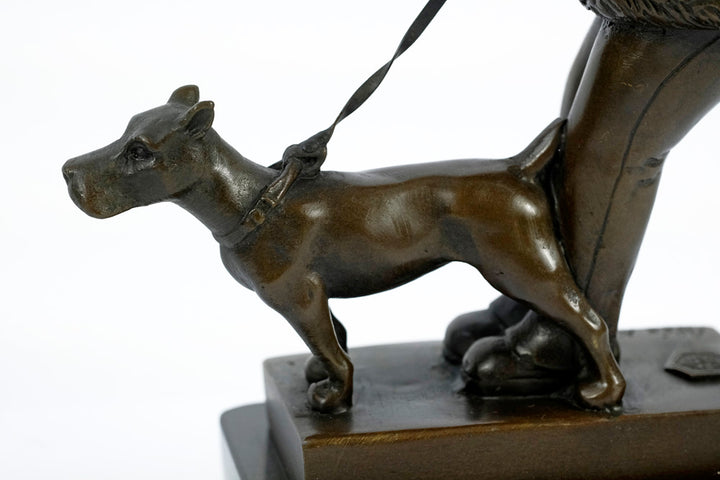 Bronze sculpture of a young girl walking her dog