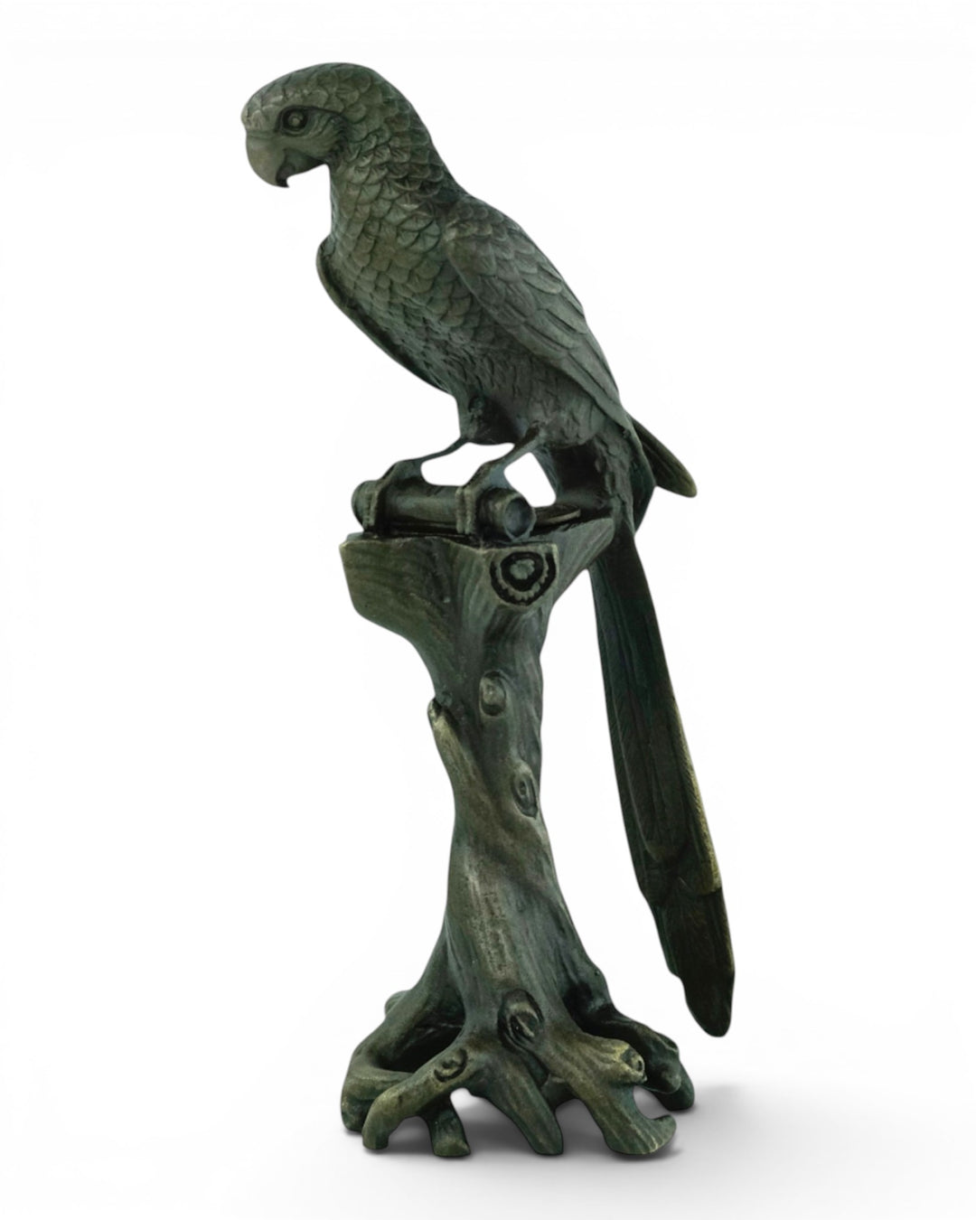 Bronze sculpture of a macaw sitting on a tree trunk