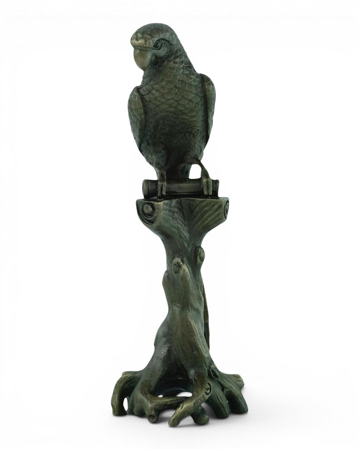 Bronze sculpture of a macaw sitting on a tree trunk