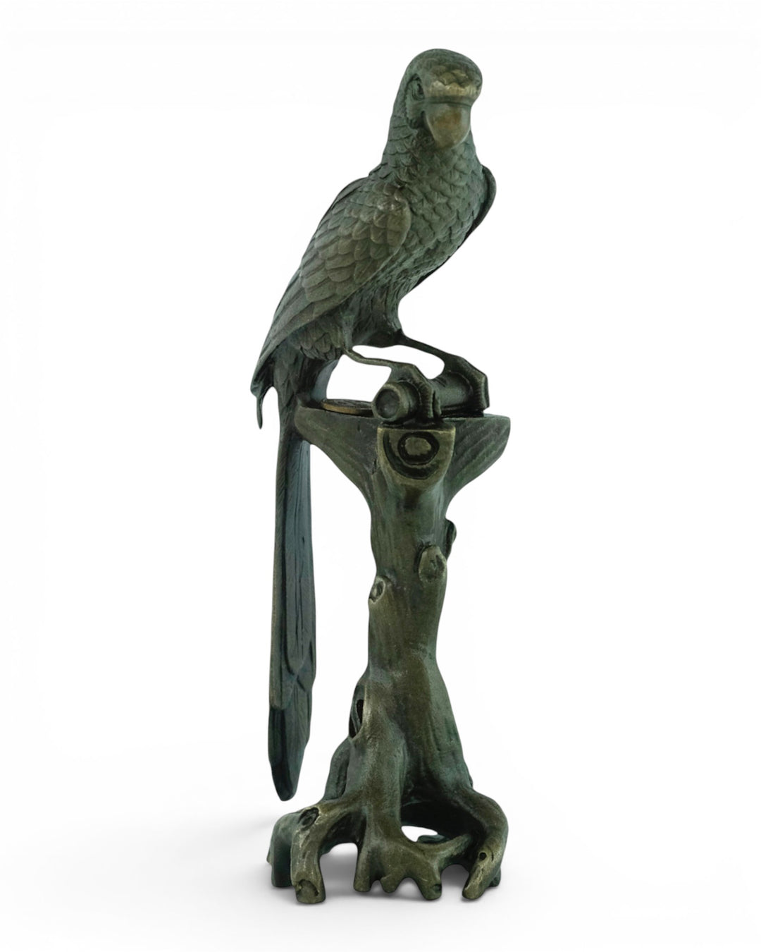 Bronze sculpture of a macaw sitting on a tree trunk