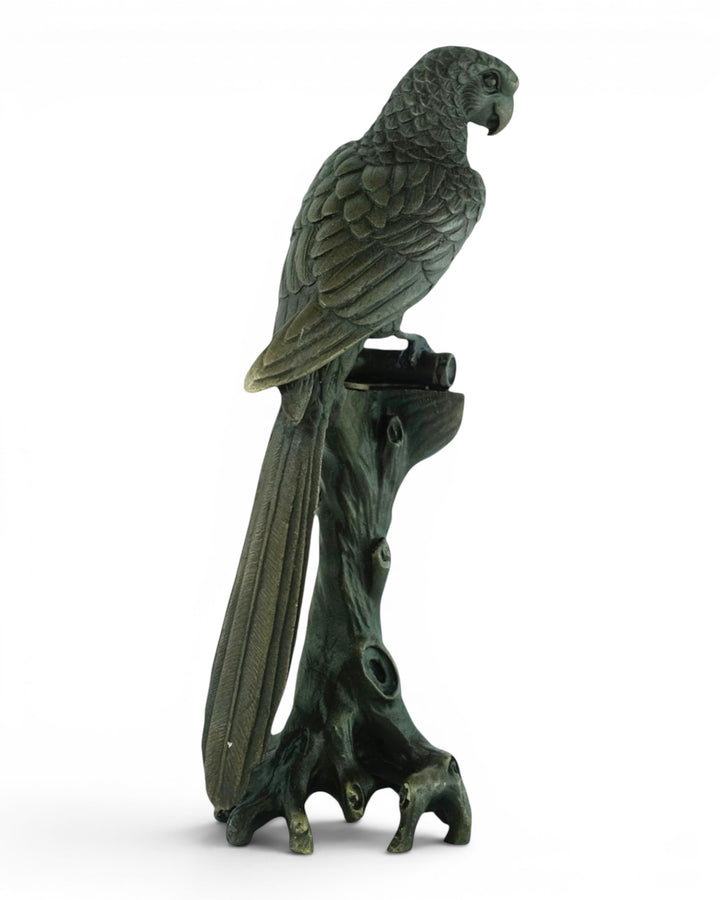Bronze sculpture of a macaw sitting on a tree trunk