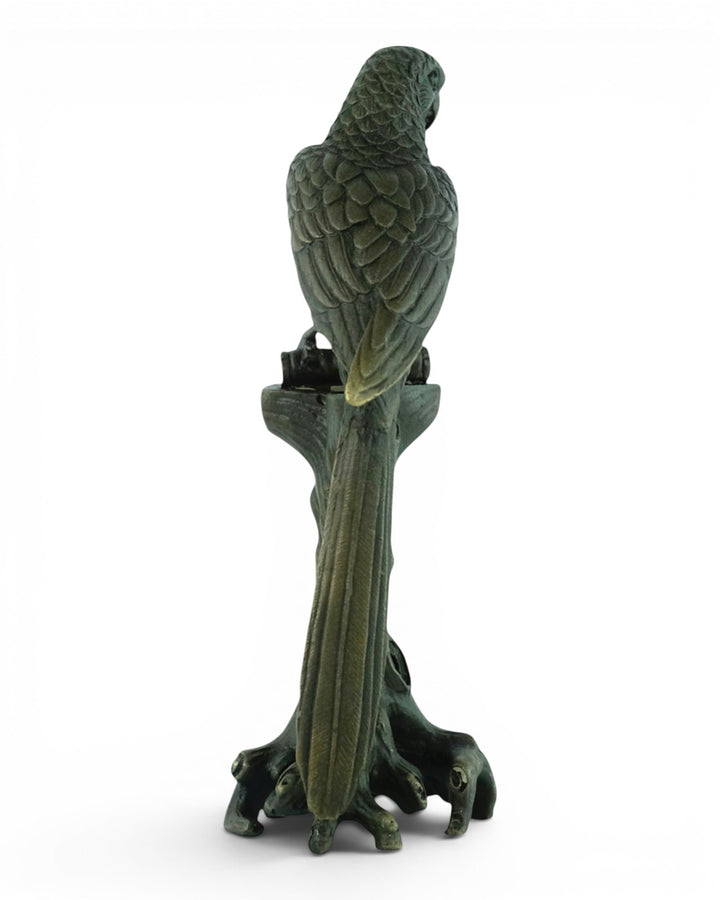 Bronze sculpture of a macaw sitting on a tree trunk