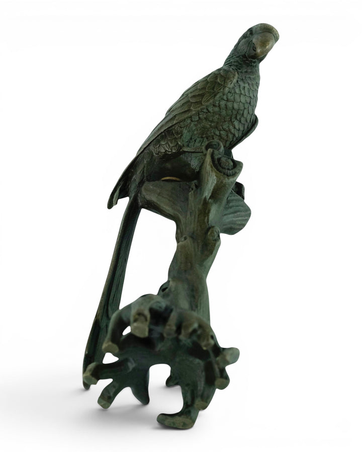 Bronze sculpture of a macaw sitting on a tree trunk
