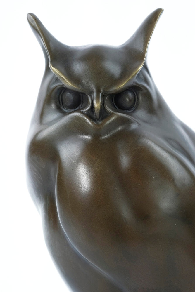 Bronze sculpture of a long-eared owl on a branch