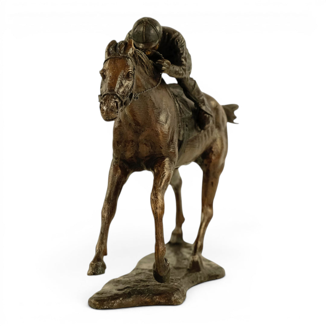 Escultura de bronce de un jinete sobre un caballo de carreras