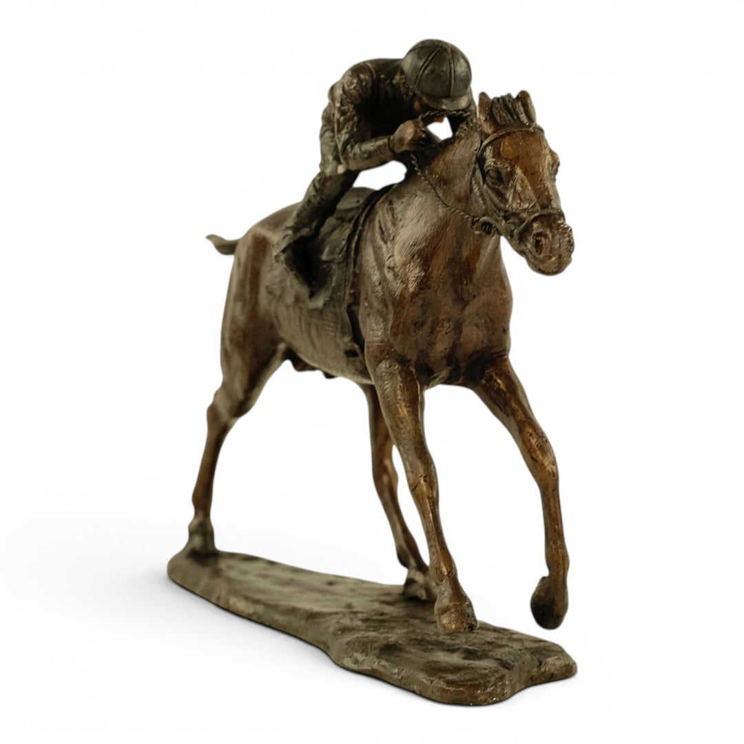 Escultura de bronce de un jinete sobre un caballo de carreras