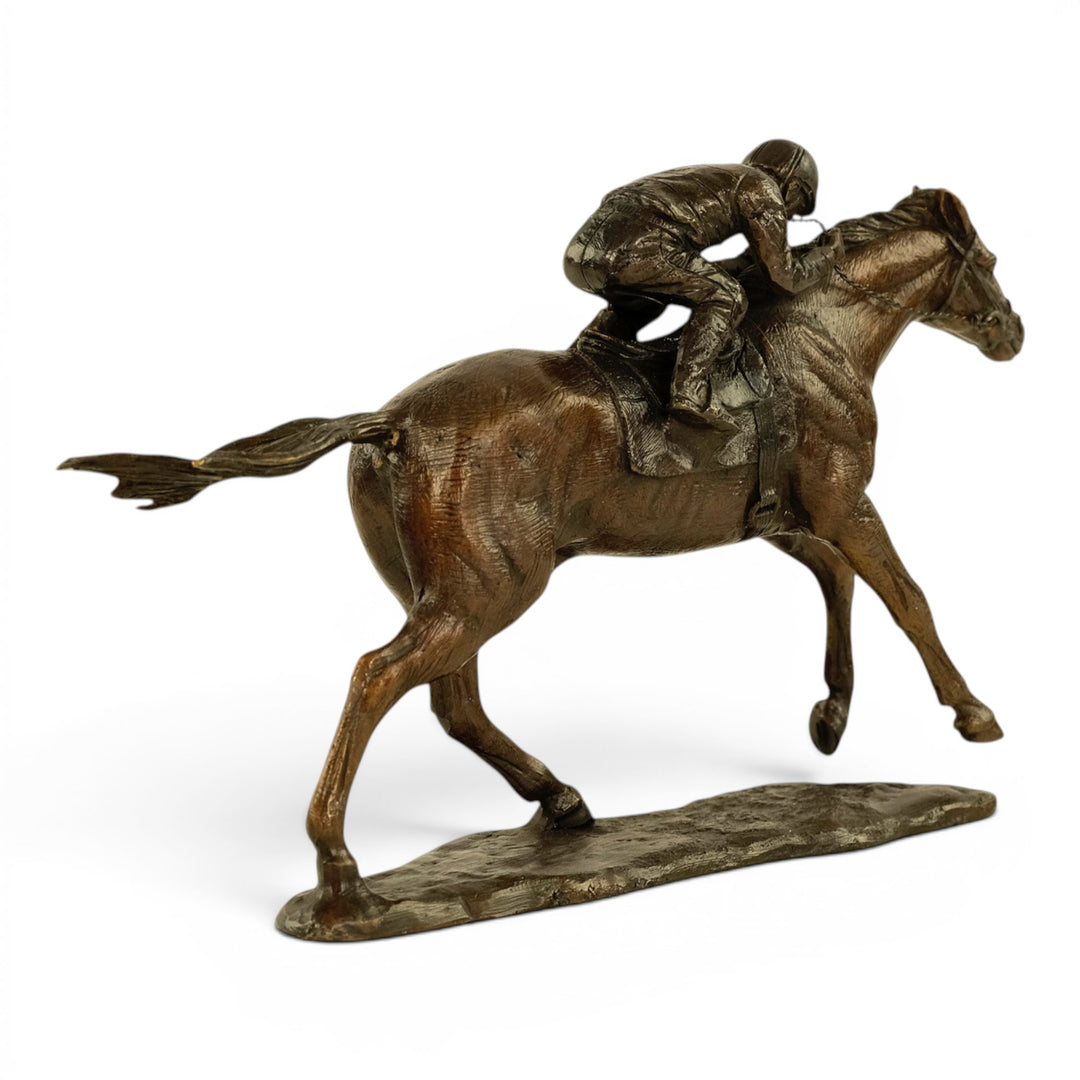 Escultura de bronce de un jinete sobre un caballo de carreras