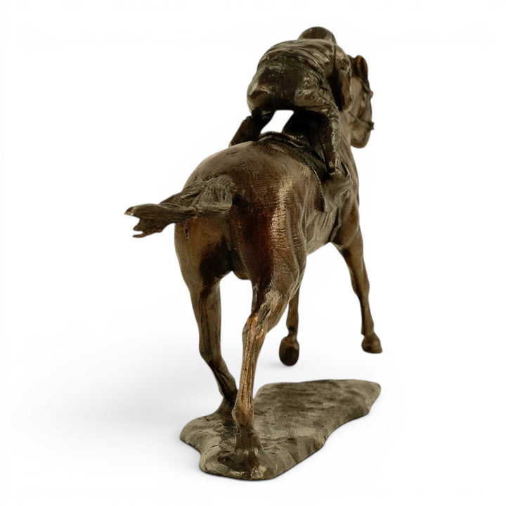 Escultura de bronce de un jinete sobre un caballo de carreras